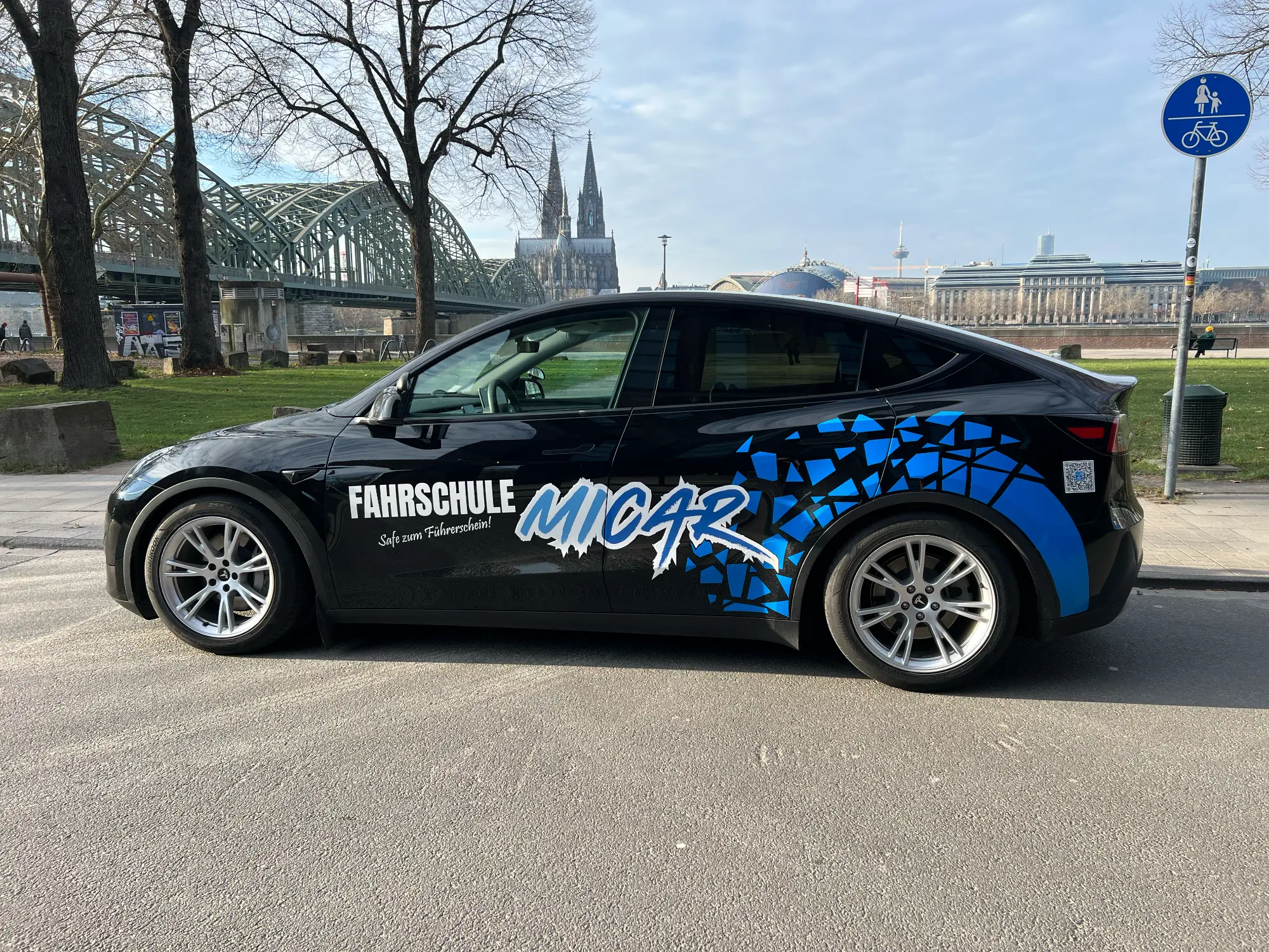 Tesla Model Y der Fahrschule MiCar in Köln – Seitenansicht